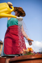 Mature Woman Watering Flowers