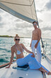 © TRAVEL EASY - Romantic smiling young couple enjoying sailing trip on a luxury summer holiday vacation, sunset and ocean in background, love and romance on a beautiful yacht