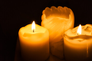 Wall Mural - Closeup of illuminated candles against a dark background