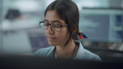 Diverse Office: Portrait of Confident Indian IT Programmer Working on Desktop Computer. Female Specialist Wearing Glasses Create Innovative Software. Professional Engineer Develop Inspirational App