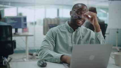 Poster - Modern Office: Portrait of Happy Black IT Programmer Working on Laptop, Talking, Brainstorming with Colleague. Male Software Engineer Wearing Glasses Develop App, Program, Video Game. Medium Shot