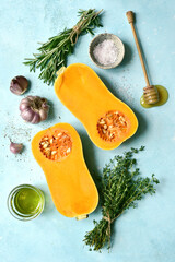 Wall Mural - Halves of raw organic butternut squash with spices and ingredients for making . Top view with copy space.