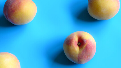 Flat Lay of Fresh Peaches Isolated on a Blue Background