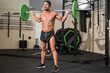 © herraez - Fit man bodybuilder doing barbell squats at gym. High quality photo.