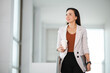 © mnirat - Portrait Of A middle-aged Asian woman Successful Business Woman Holding White take away coffee Of Hot Drink In Hand at office