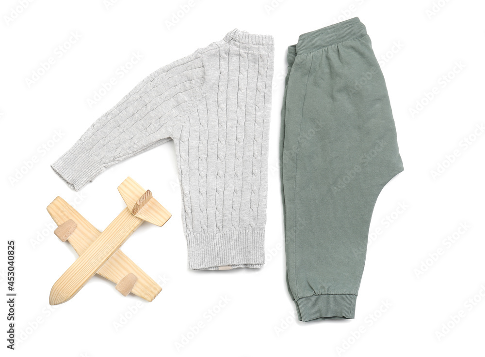 Stylish baby clothes with toy on white background