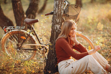 Happy Active Young Woman Riding Vintage Bicycle In Autumn Park At Sunset.