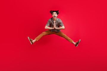 Poster - Full size photo of young crazy excited good mood guy jumping desire wish screaming isolated on red color background