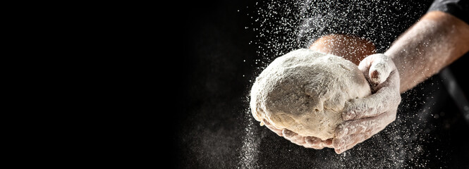 Hands of baker kneading dough isolated on black background. prepares ecologically natural pastries