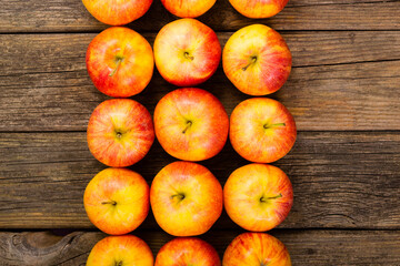 Wall Mural - apple fruits in a row, old weathered wood table background