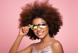 © Oleg Gekman - Beauty portrait of African American girl in colored holographic sunglasses. Beautiful black woman on pink background. Cosmetics, makeup and fashion