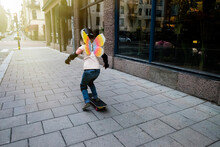 Girl Skateboarding On Sidewalk