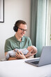 © Johnér - Father holding baby son and working from home