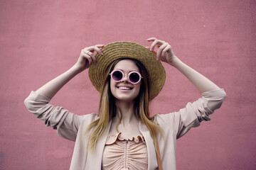 Poster - woman on the street wearing hat and glasses pink wall city trip