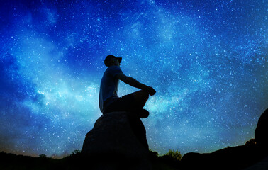 Wall Mural - silhouette of man sitting and practicing outdoors, person does yoga meditation