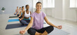 Portrait of smiling multiracial women girls sit in lotus position with mudra hands meditate together. Happy diverse multiethnic females do workout practice yoga in sports club or fitness center.