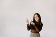 © Image Source RF - Smiling young woman pointing towards wall