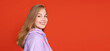 © Lustre Art Group  - Side view cropped portrait of young smiling girl isolated on red studio background. Concept of human emotions