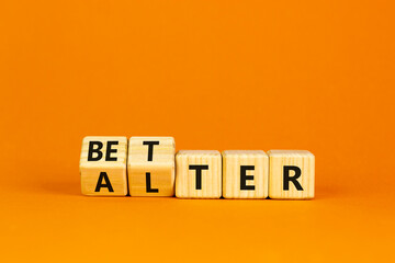 Wall Mural - Alter or better symbol. Turned wooden cubes and changed the word 'alter' to 'better'. Beautiful orange background, copy space. Business and alter or better concept.