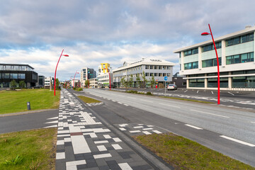 Footpath and bicycle lane along a deserted street in a business district on a summer evening. Reykjavik, Iceland.