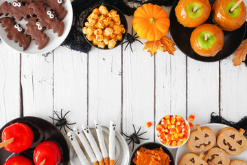 Canvas Print - Rustic Halloween treat double border over a white wood background with copy space. Top view. Mixture of candied apples, cookies, candy and sweets.