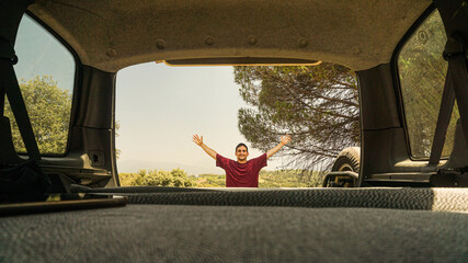 Poster - Hispanic traveler guy posing for the camera that is set up inside of his car while he is outside