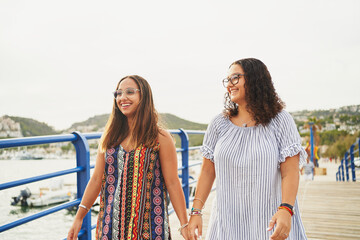 Wall Mural - 2 spanish women walk across a bridge and laugh in Port d'Andratx