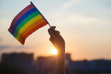 Fototapeta Londyn - Transgender woman holding rainbow flag on sky background, LGBTQ pride, parade, march concept