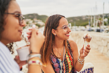 Wall Mural - Two young women eating ice cream in Port d'Andratx, Mallorca