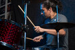 © JulianSarmiento - Young drummer playing his instrument. student making a musical composition. inspired percussionist doing a solo