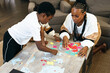 © Creative Flame - Black mother and kids put together africa puzzle