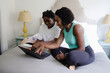 © Creative Flame - African American mother helps daughter with homework, on laptop