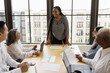 © Creative Flame - Mid Black woman leading business team meeting
