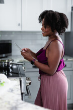 Black Woman Reading Cook Book Instructions In Kitchen