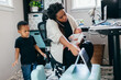 © Creative Flame - Black mother working from home with children, professional businesswoman