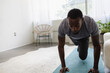 © Creative Flame - Young man exercising in living room