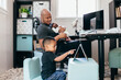 © Creative Flame - Black dad with newborn working from home helping son with schoolwork