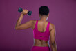 © Creative Flame - Rear view of Black woman doing dumbbell exercises