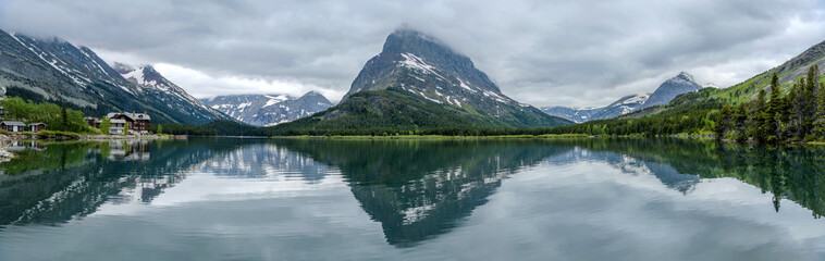 Wall Mural - Spring Mountain Lake - A stormy Spring evening view of Swiftcurrent Lake, with Mt. Grinnell towering at west shore and Mt. Wilbur disappeared in thick clouds, Glacier National Park, Montana, USA.