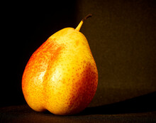 Yellow Pear Lies On A Black Background