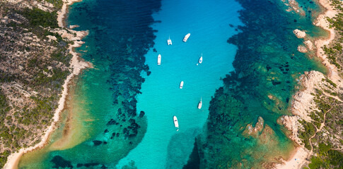 Wall Mural - View from above, stunning aerial view of a green and rocky coastline bathed by a turquoise, crystal clear water. Costa Smeralda, Sardinia, Italy.