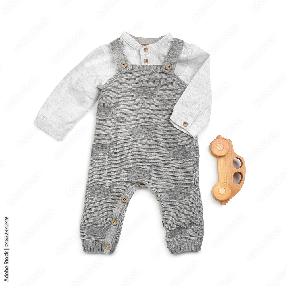 Stylish baby clothes with toy on white background