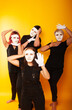 © Marina Chernivetskay - girls in white masks and white gloves in the image of mimes an unseen wall show hands actors of theater and cinema, the concept of advertising a shopping center