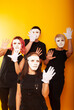 © Marina Chernivetskay - girls in white masks and white gloves in the image of mimes an unseen wall show hands actors of theater and cinema, the concept of advertising a shopping center