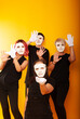 © Marina Chernivetskay - girls in white masks and white gloves in the image of mimes an unseen wall show hands actors of theater and cinema, the concept of advertising a shopping center