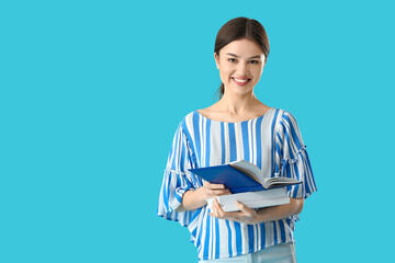 Canvas Print - Young woman with books on color background