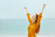 © PinkCoffee Studio - Freedom concept. Young beautifel woman on the beach raises her hands up