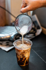 Sticker - ice latte coffee in plastic glass on black table at cafe​