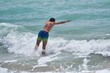 Młodzież aktywnie wypoczywająca w słoneczny letni dzień nad ciepłym morzem, kąpiele morskie wśród fal.