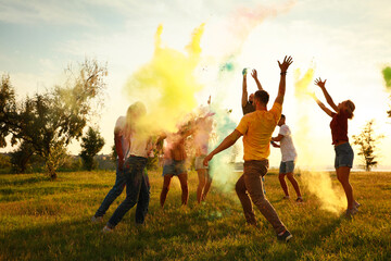 Wall Mural - Happy friends having fun with colorful powder dyes outdoors. Holi festival celebration